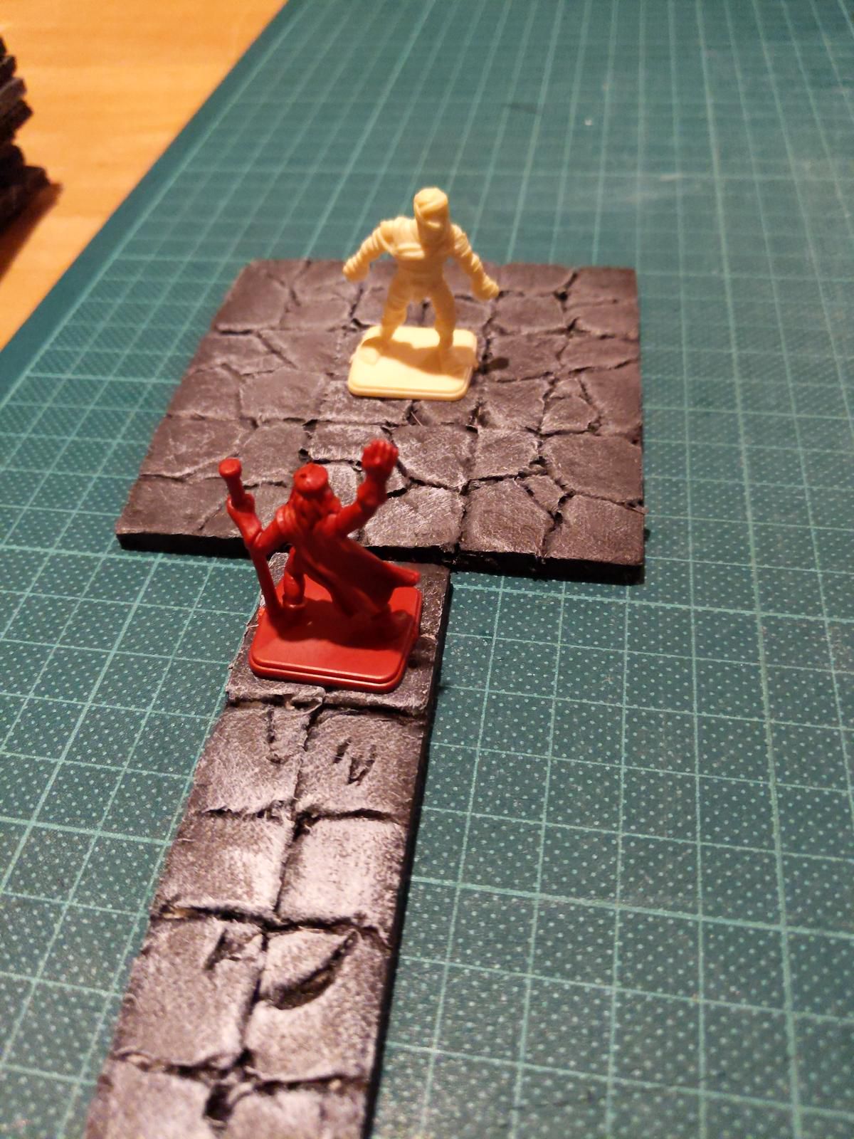Ein Bild mit styropor dungeon tiles und zwei mini figuren darauf